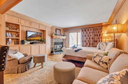 a living room with a bed and a couch and a tv at Cozy Studio Wood Fireplace in Ellicottville