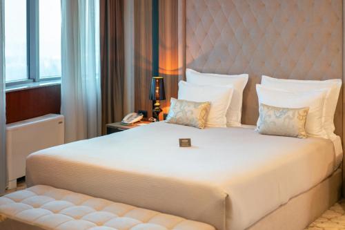 a bedroom with a large bed with a large headboard at Radon Plaza in Sarajevo