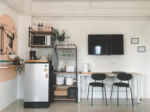 a kitchen with a refrigerator and a table and two stools at The Giftown Bangkok, Talat Phlu in Thonhuri