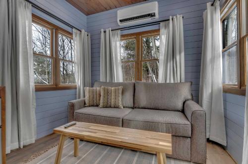 a living room with a couch and a coffee table at Modern Tiny Home Wraparound Deck in Great Valley