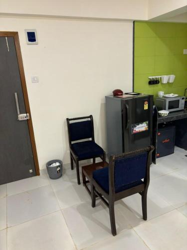 a kitchen with two chairs and a refrigerator at Ivy Bliss Studio with Private Pool, B 09, Karjat in Karjat