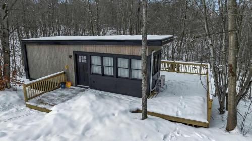 a small cabin in the snow in the woods at Modern Tiny Home Wraparound Deck in Great Valley