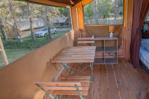 - une terrasse couverte dans une tente avec une table et des chaises dans l'établissement Camping Onlycamp Les Mélèzes, à Ceillac