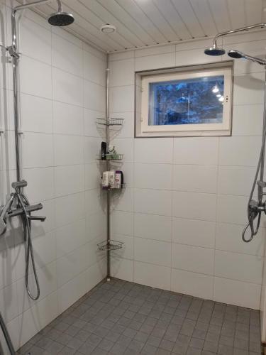 a bathroom with a shower and a window at Hostelli Jokiranta in Lieksa