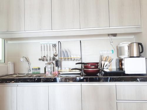 a kitchen with white cabinets and a counter top at Ehsan Residence KLIA Nilai , USIM, SEPAANG F1 Circuit, Xiamen University in Kampong Baharu Cheras Batu Sembilan