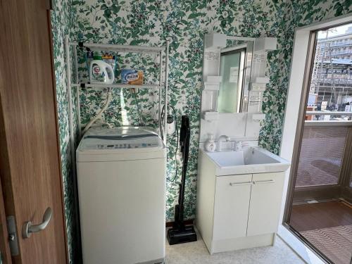 a small bathroom with a sink and a mirror at Guest House新今宫 in Osaka