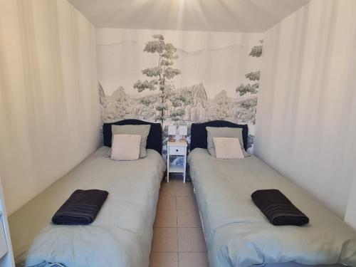 deux lits jumeaux dans une chambre avec un mur dans l'établissement Appartement familial tout équipé, à Angers