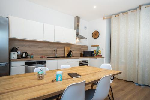 une cuisine avec une table en bois et des armoires blanches dans l'établissement Le Perchoir- Grand Valtin 6 pers, à Ban-sur-Meurthe-Clefcy