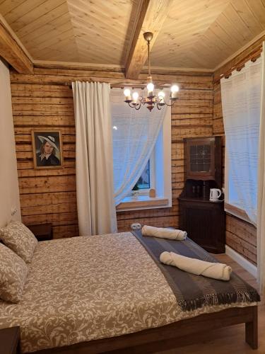 una camera da letto con un letto e un lampadario di Stebuklėlis a Pakruojis