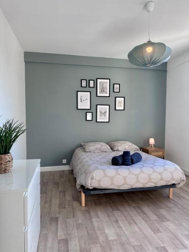 - une chambre dotée d'un lit avec des photos sur le mur dans l'établissement Casa Ribot #10 - T4 pour 5 personnes - Proche Centre Ville, à Brive-la-Gaillarde