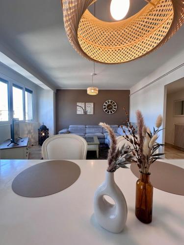 - un salon avec une table et un vase fleuri dans l'établissement Casa Ribot #10 - T4 pour 5 personnes - Proche Centre Ville, à Brive-la-Gaillarde