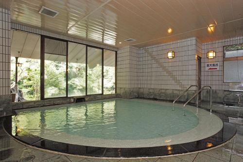 a large swimming pool in a building with a pool at Shiunso in Hakone