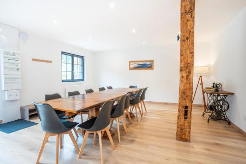 una sala de conferencias con una mesa y sillas de madera en Le Perchoir du Grand Valtin - Gîte 9 personnes - Altitude 830, en Ban-sur-Meurthe-Clefcy