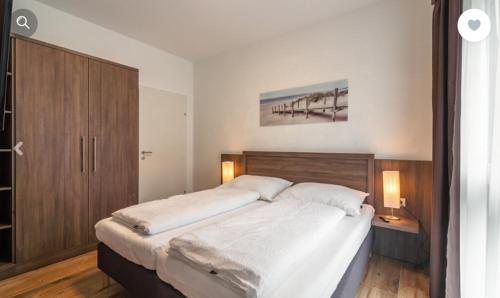 a bedroom with a large bed with a wooden headboard at Stadtdomizil TOP 10 in Schladming