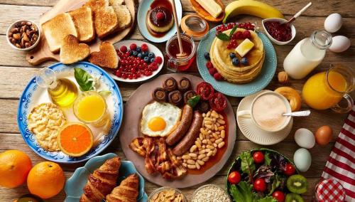 une table avec des assiettes de petits-déjeuners et de boissons dans l'établissement Soirée romantique LOVE ROOM, à Allez-et-Cazeneuve