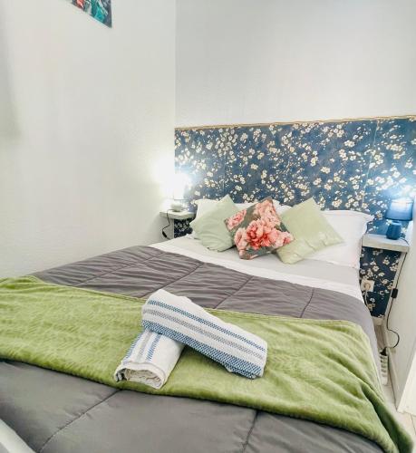 - une chambre avec un grand lit fleuri dans l'établissement Joli appartement avec piscine, à Sète