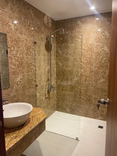 a bathroom with a sink and a glass shower at SÀI GÒN - BẠC LIÊU Hotel in Bạc Liêu
