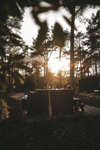 a sunset in a park with a couch and a guitar at KampinaStaete Diamond Suite met Hottub in Oisterwijk