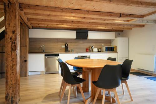 une cuisine et une salle à manger avec une table et des chaises en bois dans l'établissement Le Perchoir du Grand Valtin - Gîte 5 personnes - Altitude 830, à Ban-sur-Meurthe-Clefcy