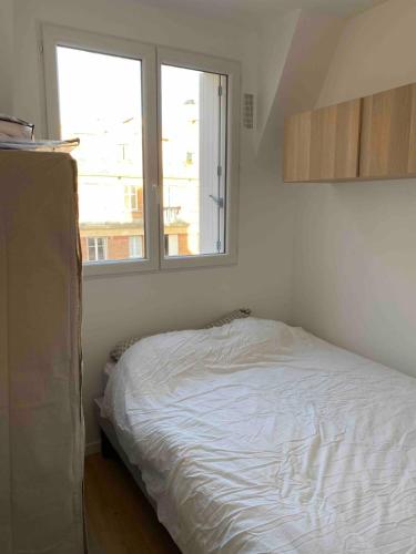 une petite chambre avec un lit et une fenêtre dans l'établissement Paris apartment with room near Tour Eiffel, à Paris