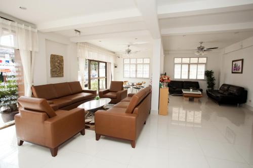 a living room with couches and a table at Top Hostel (Top Mansion) in Udon Thani