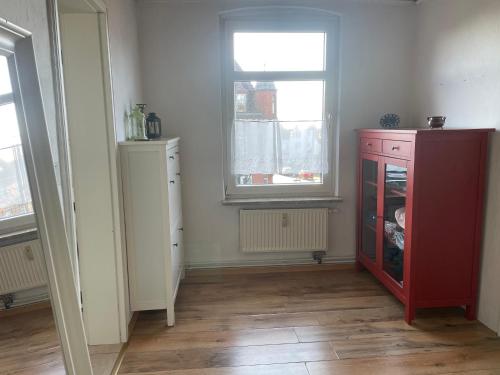a room with a red cabinet and a window at Fewo Itzehoe in Itzehoe