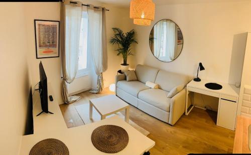 un salon avec un canapé et un miroir dans l'établissement Studio Downtown Private Parking, à Montlhéry