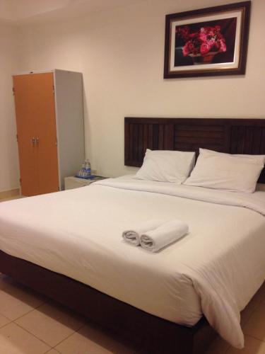 a bedroom with a large bed with two towels on it at Top Hostel (Top Mansion) in Udon Thani