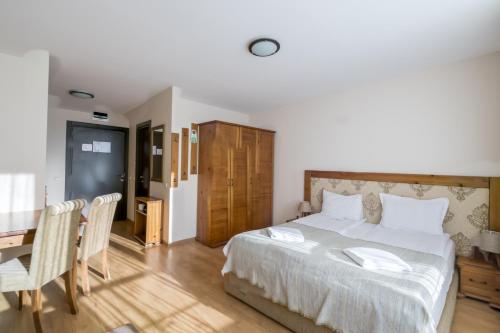 班斯科Cornelia Deluxe Residence的一间卧室，里面有一张床、一张桌子和几把椅子。