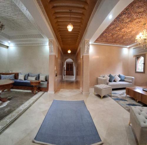 a large living room with couches and a rug at Villa Hamza Marrakech in Bou Touil