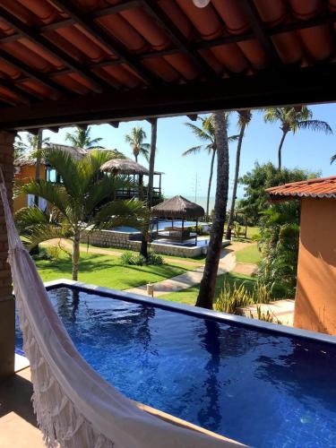 a hammock on a porch with a view of a resort at Pousada Spa dos Amores in São Miguel do Gostoso