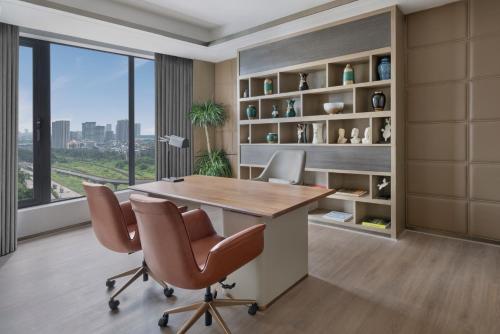 an office with a desk and chairs and a window at Navi Mumbai Marriott in Navi Mumbai