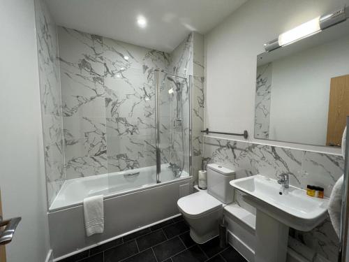 a bathroom with a sink and a toilet and a bath tub at House of Fisher - 100 Kings Road in Reading