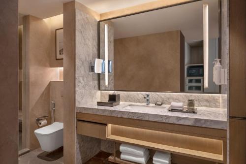 a bathroom with a sink and a mirror at Navi Mumbai Marriott in Navi Mumbai