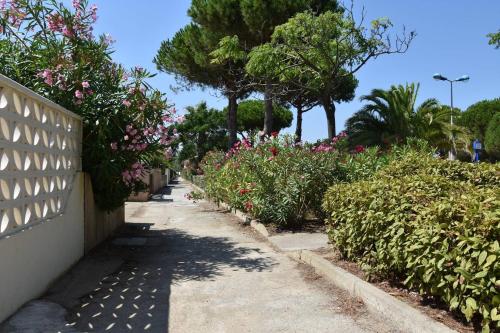 un trottoir avec des fleurs et des arbres et une clôture dans l'établissement Maison Studio mezzanine - Gruissan Ayguades AY030-203, à Vires