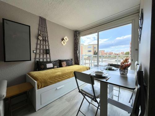 - une petite chambre avec un lit, une table et une salle à manger dans l'établissement Appartement 2 pièces - Gruissan GN300-1007, à Gruissan