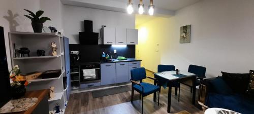 a kitchen with a table and chairs in a room at Villa Erdődy Resort - Apartmán U veveričky in Oravská Lesná