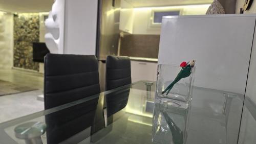 a parrot sitting in a glass vase on a table at Alexandra's Home in Fira