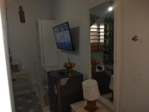 a living room with a television and a desk with a chair at Nyumba Tulivu in Watamu