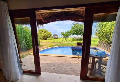 a view of a pool from the door of a room at Pousada Spa dos Amores in São Miguel do Gostoso