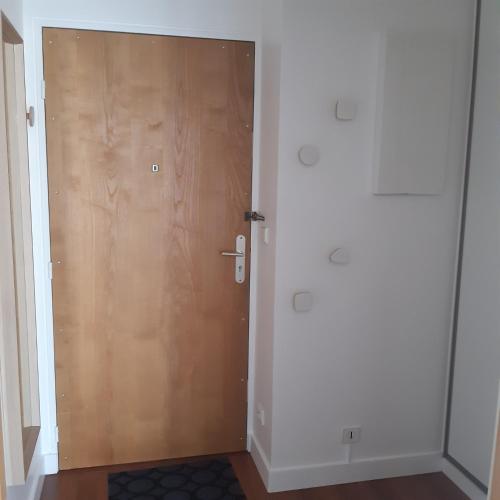 - une porte dans une chambre avec une porte en bois dans l'établissement Charmant studio, à La Garenne-Colombes