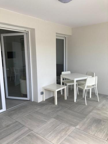 a white dining room with a table and chairs at Entre ville et océan, 3 étoiles, lumineux et calme en plein centre-ville in Saint-Médard-en-Jalles