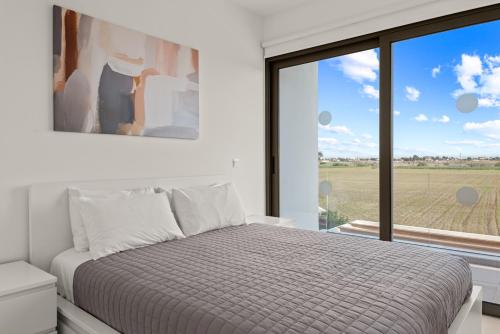 Un dormitorio con una cama y una ventana grande. en Serenity Waves Villa 20, en Lárnaca