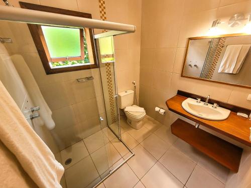 a bathroom with a sink and a toilet and a mirror at Pousada Victoria Villa By Nacional Inn - A 800 metros da Vila Capivari in Campos do Jordão
