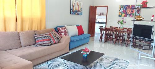 a living room with a couch and a table at Temporada Belas Casas in São Pedro