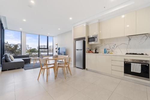 a kitchen and living room with a table and chairs at 04M New 1BR apartment near Airport and City with Free visitor parking in Sydney