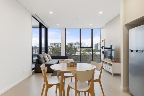 a kitchen and living room with a table and chairs at 04M New 1BR apartment near Airport and City with Free visitor parking in Sydney