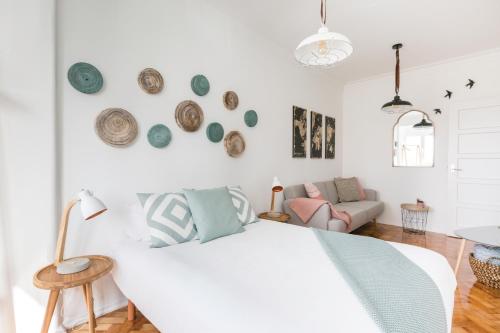 a white bedroom with a bed and a couch at Panoramic River View 1-BR near Senhora do Monte by NestAtLisbon in Lisbon