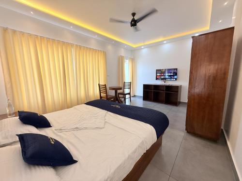 a bedroom with a large bed and a dining room at Golden Sands Cherai in Cherai Beach