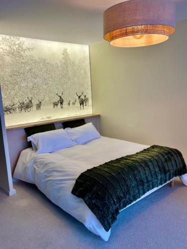 une chambre avec un lit avec un tableau sur le mur dans l'établissement Alpe d 'Huez - Le Majestic, à Huez